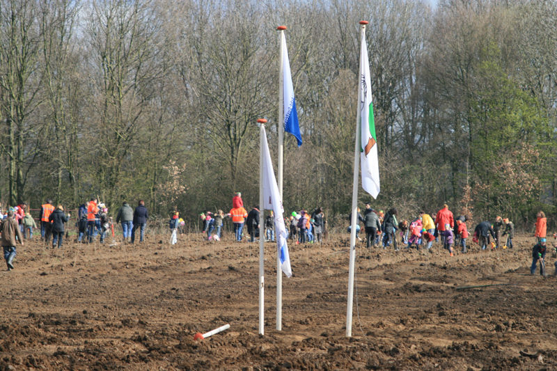 Kinderen druk bezig met het planten van de bomen