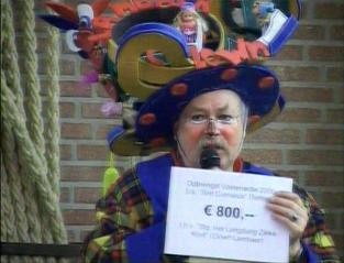 Clown Lambaer neemt de cheque in dank aan voor het langdurig zieke kind