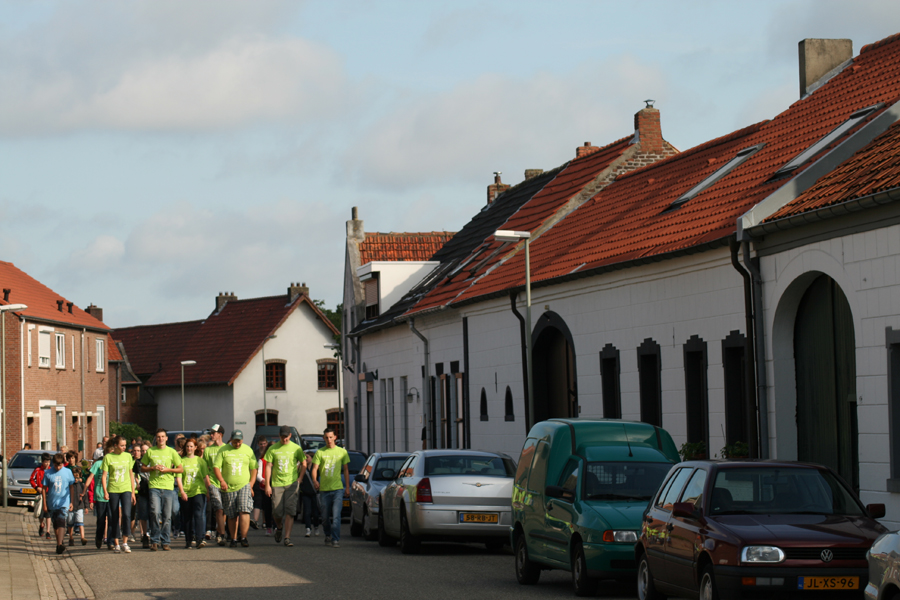 KVW leiding en kinderen lopen door de straten van Dieteren richting KVW terrein