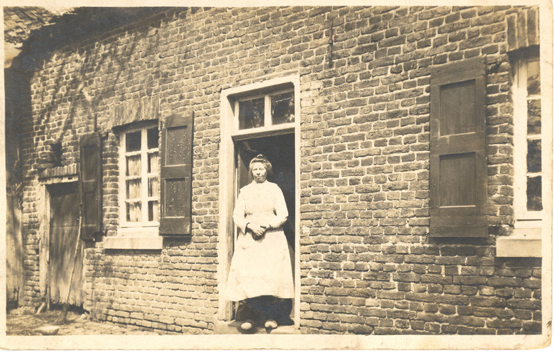 Mrie van Ties Jessen in de deuropening van haar woning aan de Kerkstraat