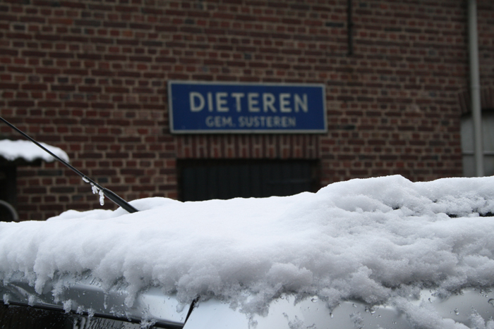 Sneeuw die een tijdje bleef liggen op daken en auto's