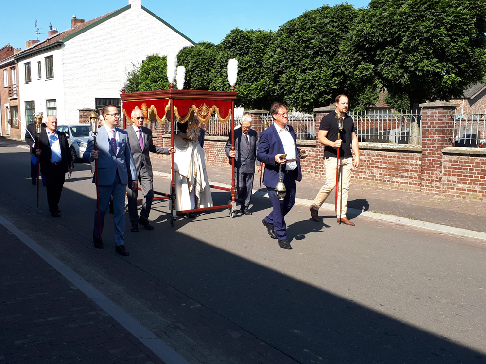 Priester met Monstrans onder ‘hemel’ onder begeleiding van flambouw dragers