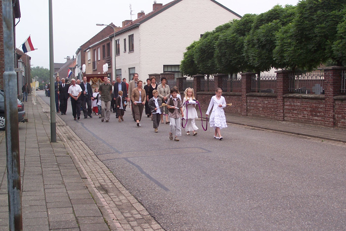 Communicantjes en priester met het allerheiligste in aantocht